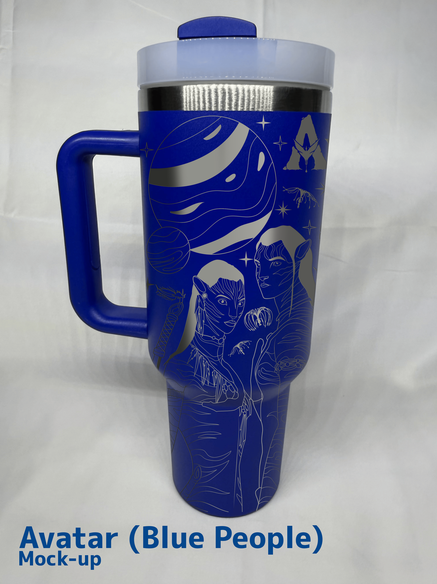 A blue 40oz engraved tumbler featuring an Avatar-inspired design. The engravings depict two Na'vi characters with intricate details, along with elements such as a large planet, floating mountains, and Pandora's unique flora. The tumbler has a handle, a clear lid, and stainless steel accents. The background is a white fabric surface, and "Avatar (Blue People) Mock-up" is written in bold blue text at the bottom left corner.